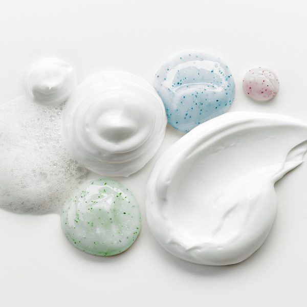 composition of various cosmetic creams on white background, top view